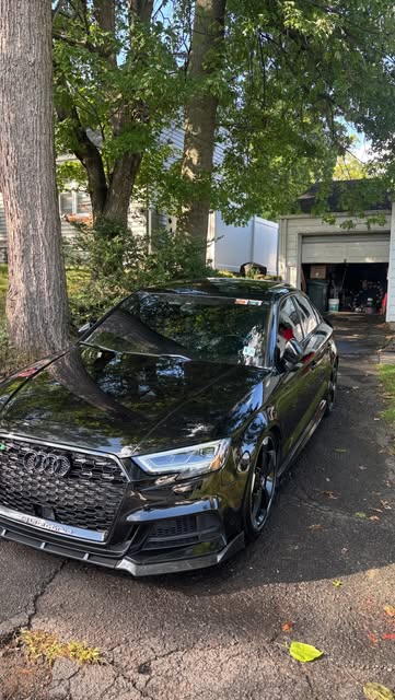 Black Audi sedan in a driveway after a detail