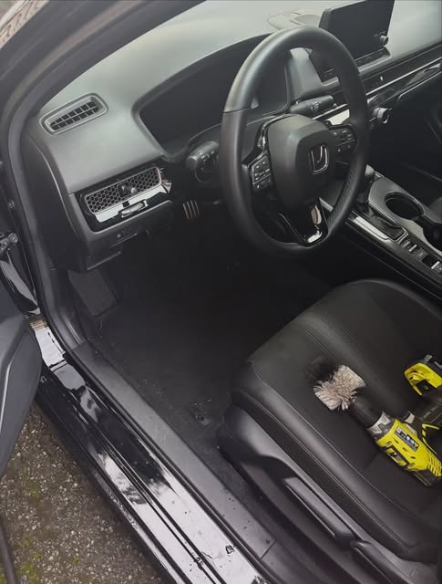Clean Honda Civic interior with the detailing drill brush on the seat